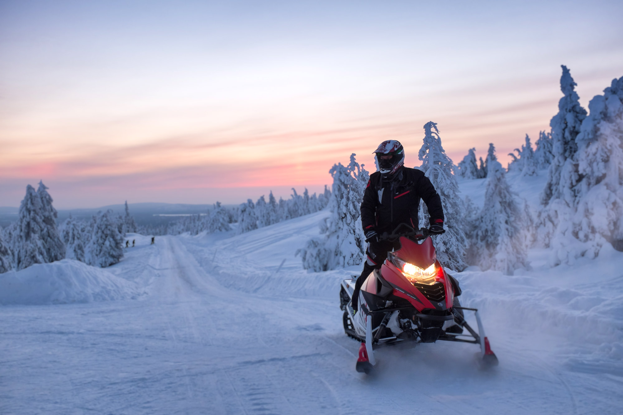 Elev som övningskör på Luleå trafikskolas röda skoter i vinterlandskap